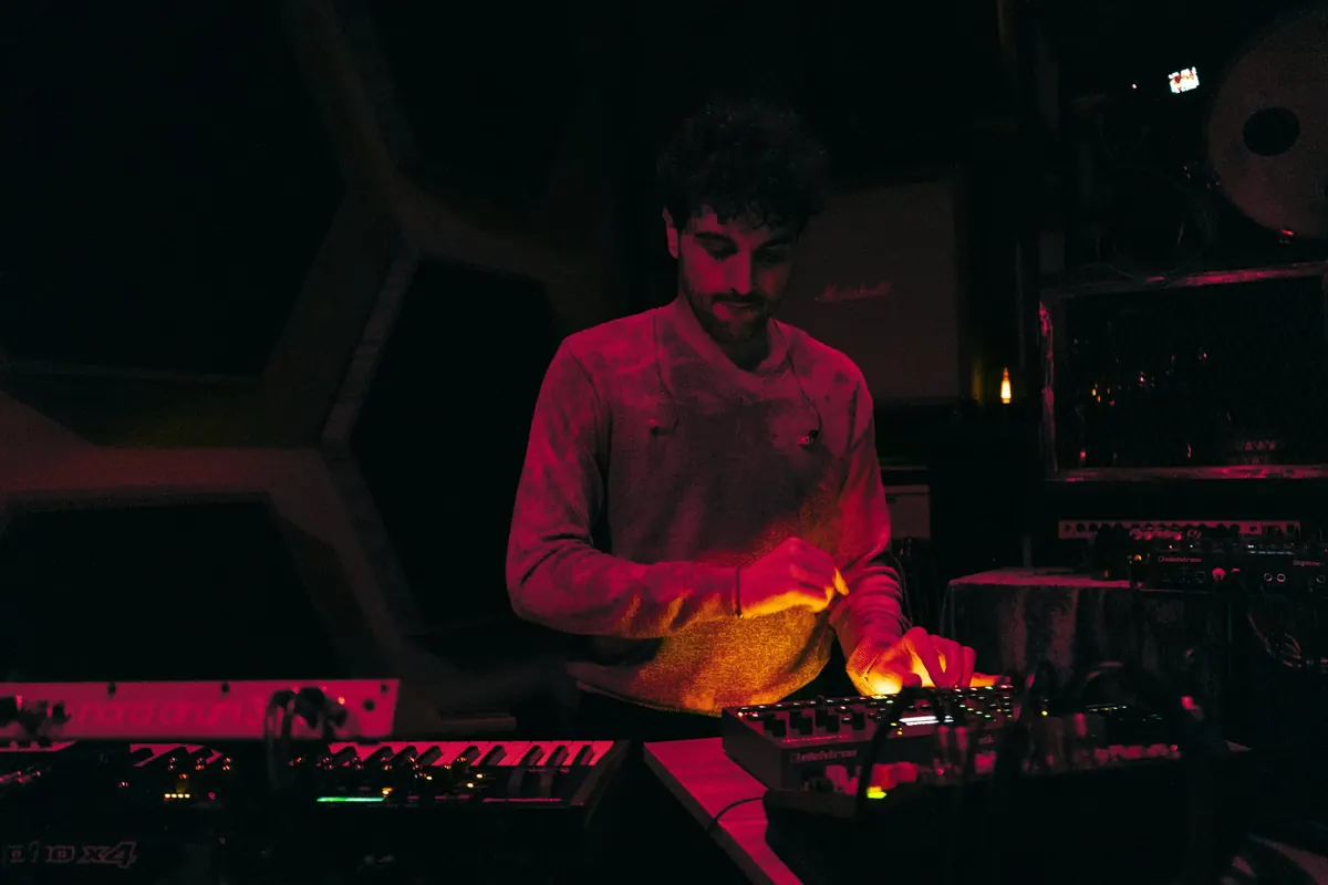 Musician at the synthesizers in red light